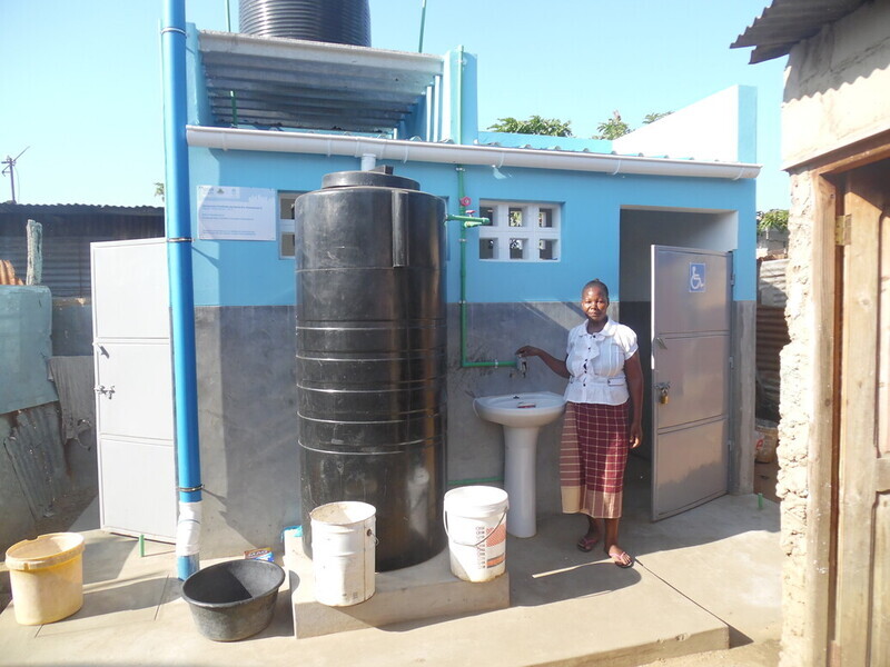Photo of a woman accessing shared sanitation facilities in Mozambique